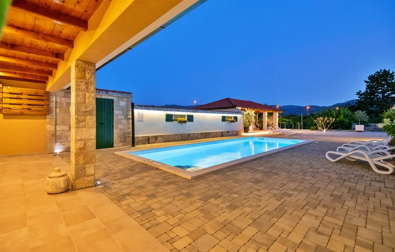 Villa Žarka exterior beautifully lit at night with pool and terrace in Zavojane, Croatia
